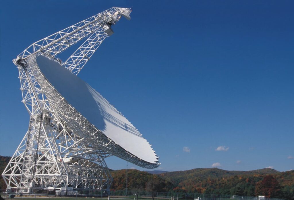 Immense parabole blanche du Green Bank Telescope entourée de collines boisées.