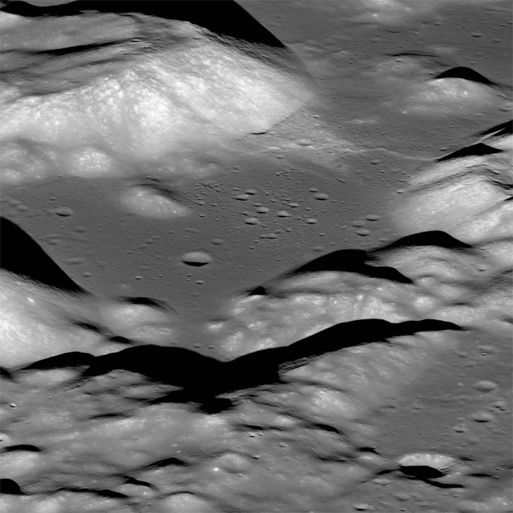Vallon Taurus‑Littrow vu en oblique depuis l’orbite : terrain fortement cratérisé, reliefs escarpés et ombres marquées montrant des falaises et des rides de compression, au premier plan des escarpements prononcés.