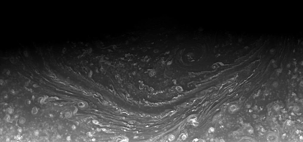 Vue rapprochée de nuages de Saturne laissant apparaître deux côtés de l’hexagone situé près du pôle Nord.