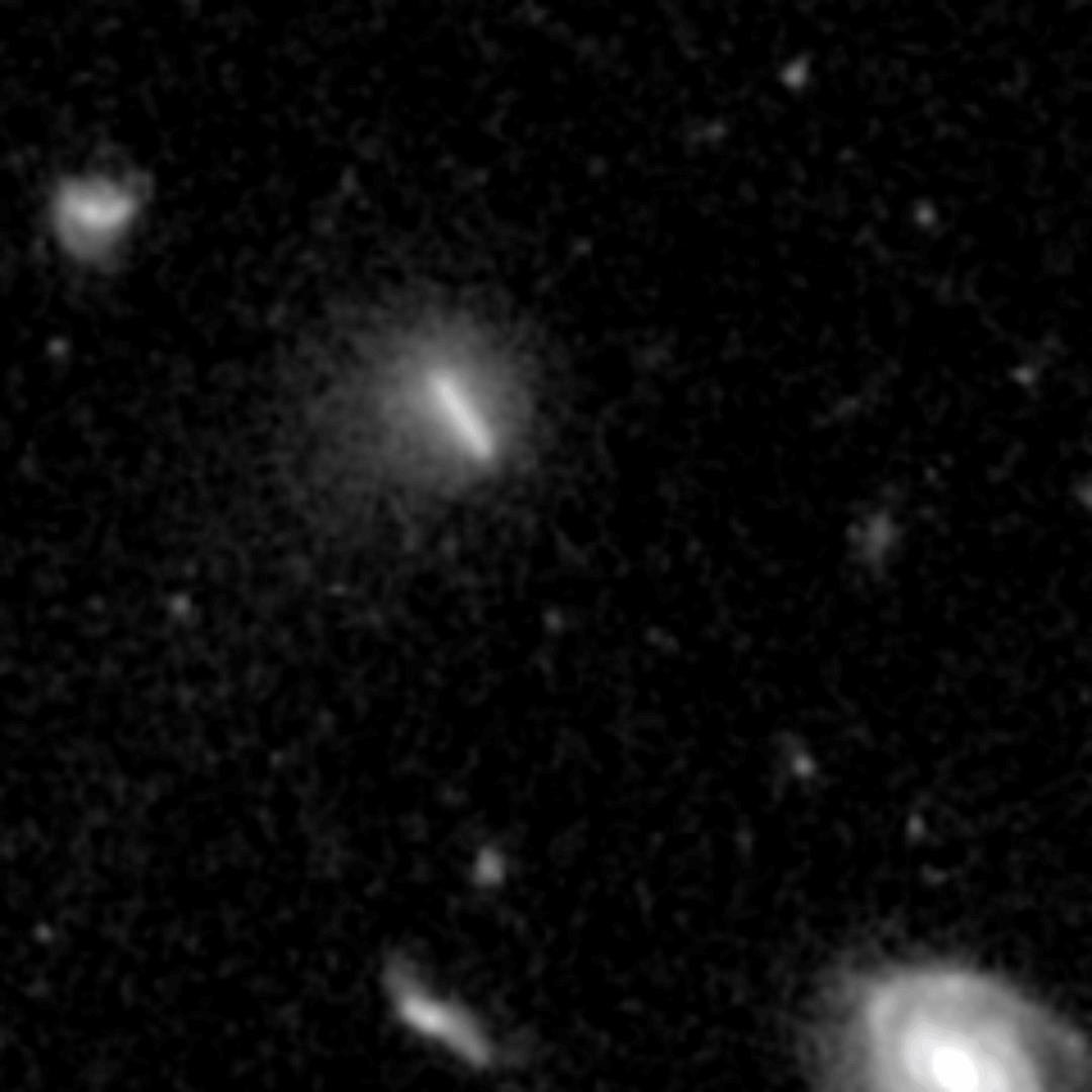 Animation en noir et blanc montrant une petite comète floue qui déplace une courte traînée lumineuse parmi des étoiles et des galaxies fixes.