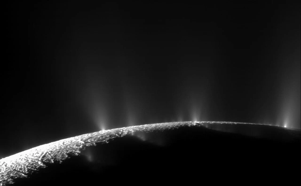 Horizon du pôle Sud d’Encelade montrant plusieurs panaches de vapeur et de grains de glace s’échappant le long de fractures brillantes.