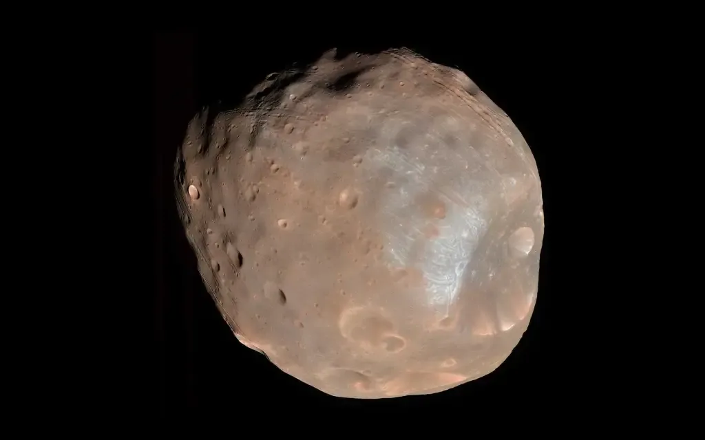 Phobos, lune irrégulière et cratérisée de Mars montrée en gros plan sur un fond noir.